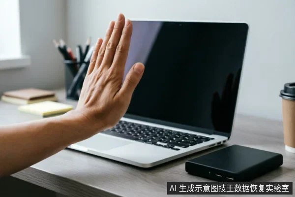画面展示了一只手在笔记本电脑前做出明显的“停止”手势,掌心向外。桌面上放置着一台银色笔记本电脑和一个黑色的外接移动硬盘盒。背景中有笔筒、便签和咖啡杯,构成了典型的办公桌面场景,直观传达了面对设备故障时立即停止操作、暂停使用的建议。
