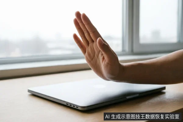 画面展示了一只手在闭合的笔记本电脑前做出明确的“停止”手势,掌心向外。背景为模糊的窗景,桌面整洁,仅有一台处于关闭状态的银色笔记本,直观传达了拒绝操作或暂停使用的意图。
