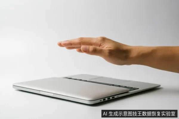 一只手掌悬停在闭合的银色笔记本电脑上方,做出停止或保护的手势。背景为纯净的灰白色,无其他杂物,画面简洁清晰,强调对设备的干预与防护概念。