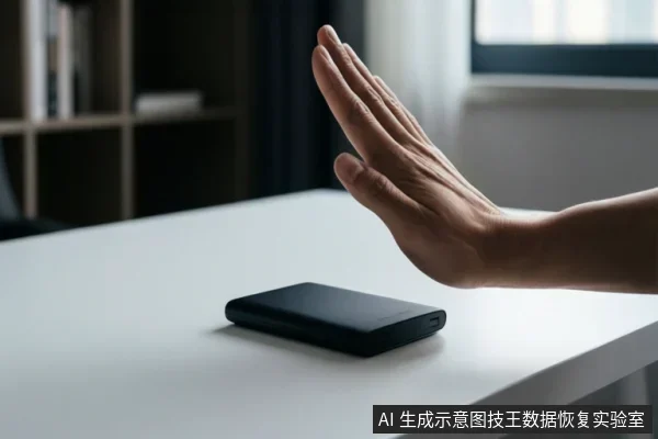 白色桌面上放置一个黑色移动硬盘,一只手掌在设备上方做出停止手势,背景为室内书架与窗户。