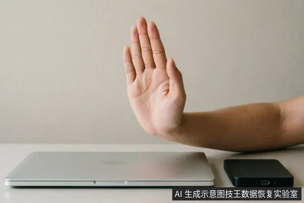 一只手掌在闭合的笔记本电脑和移动硬盘前做出明确的“停止”手势,示意拒绝或中断操作。画面主体清晰,无屏幕文字,通过肢体语言传达出在特定故障下应暂停软件尝试、避免进一步风险的含义。