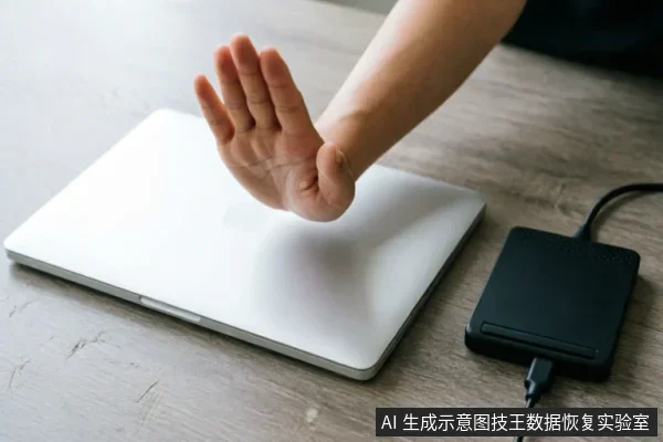 一只手掌在银色笔记本电脑上方做出停止手势,旁边连接着一个黑色的外接硬盘盒,示意在设备异常时立即停止通电操作。