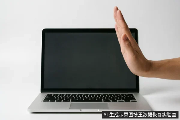 一台屏幕黑屏的银色笔记本电脑放置在白色背景上,一只手掌从右侧伸出,掌心面向电脑,做出明确的“停止”或“拒绝”手势。