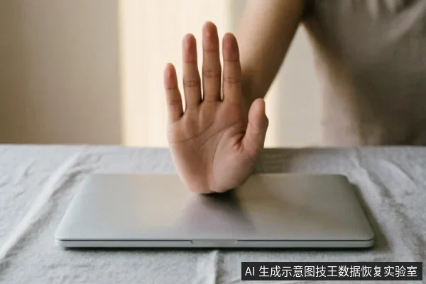 一只手掌在合上的银色笔记本电脑上方做出明显的“停止”手势，掌心向外，示意禁止操作或暂停使用。