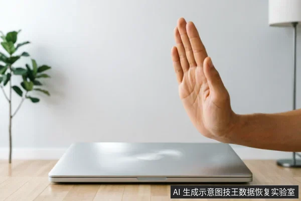 一只手掌在闭合的银色笔记本电脑前做出明显的“停止”手势,示意拒绝操作。背景为简洁的桌面环境,包含绿植和台灯。画面直观传达了面对存储设备故障时立即停止写入、断电及禁止自行修复的核心止损理念。